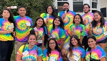 Group of students in colorful tie-dye shirts in front of La Casa