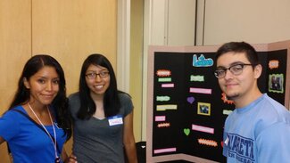 Three students standing in front of their display board