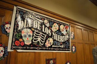 Día De Los Muertos banner with stylized skeletons hanging on wall