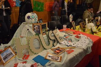 Decorated table with various photos, items, and large cutout letters forming the word 'House' 