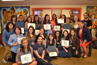 Large group of attendees smiling with many holding certificates in La Casa room